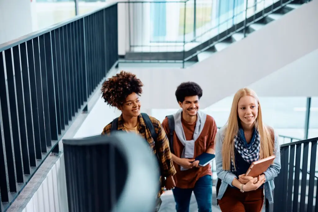 Multiracial group of happy college students in a hallway.